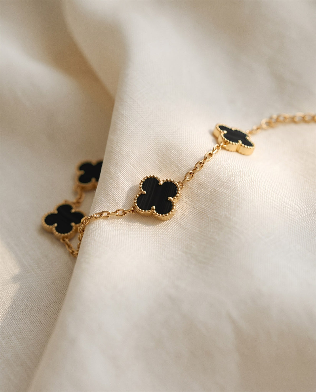 The Clover Bracelet in black on ivory linen