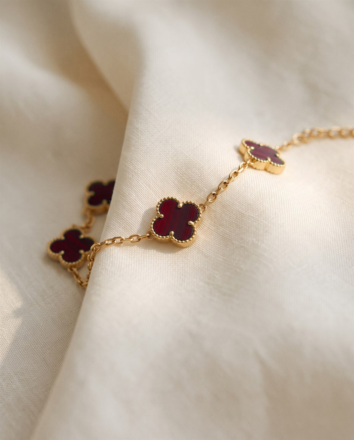 The Clover Bracelet in red on ivory linen
