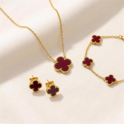 The Clover Set in red: necklace, bracelet and studs on ivory linen